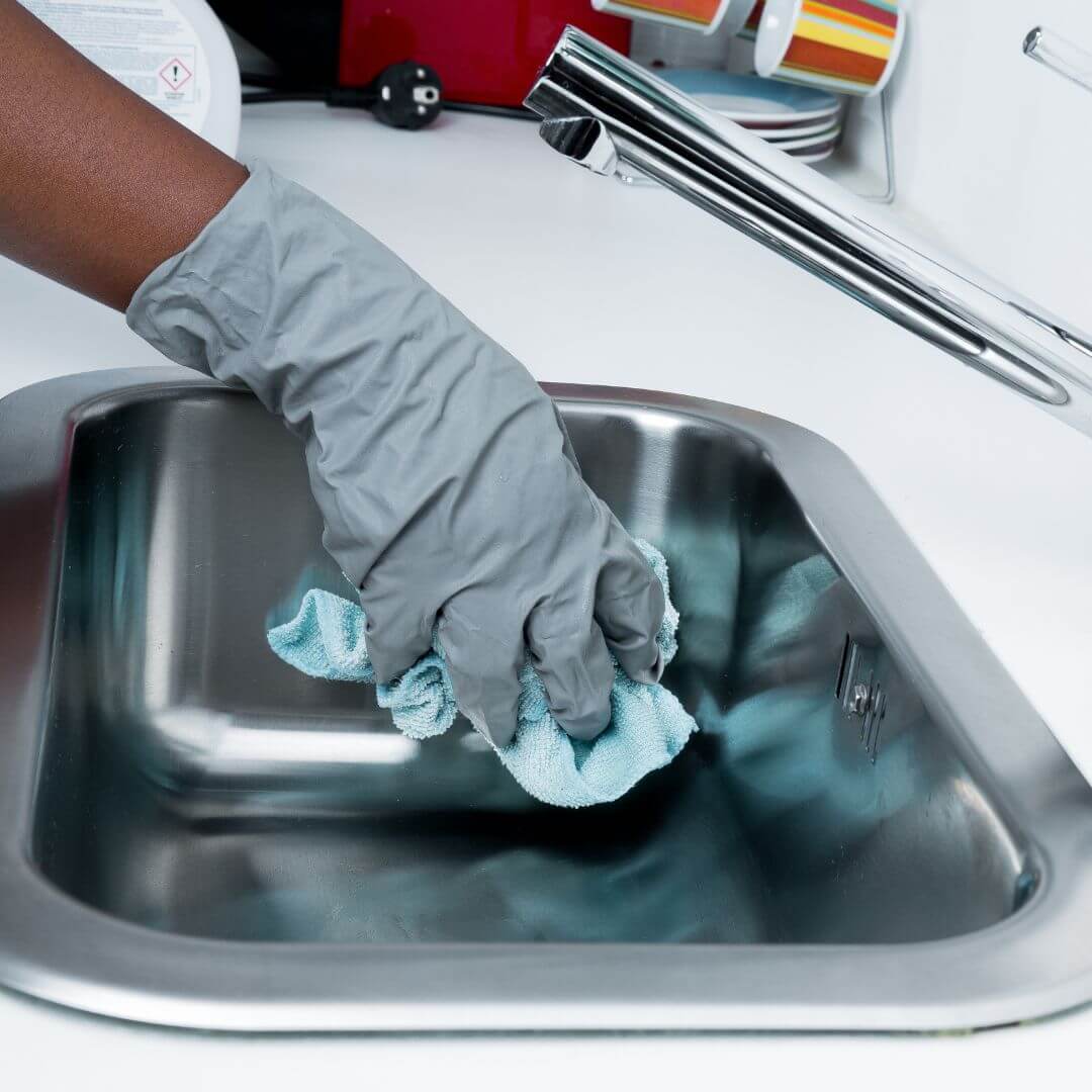 image of a cleaner scrubbing a sink