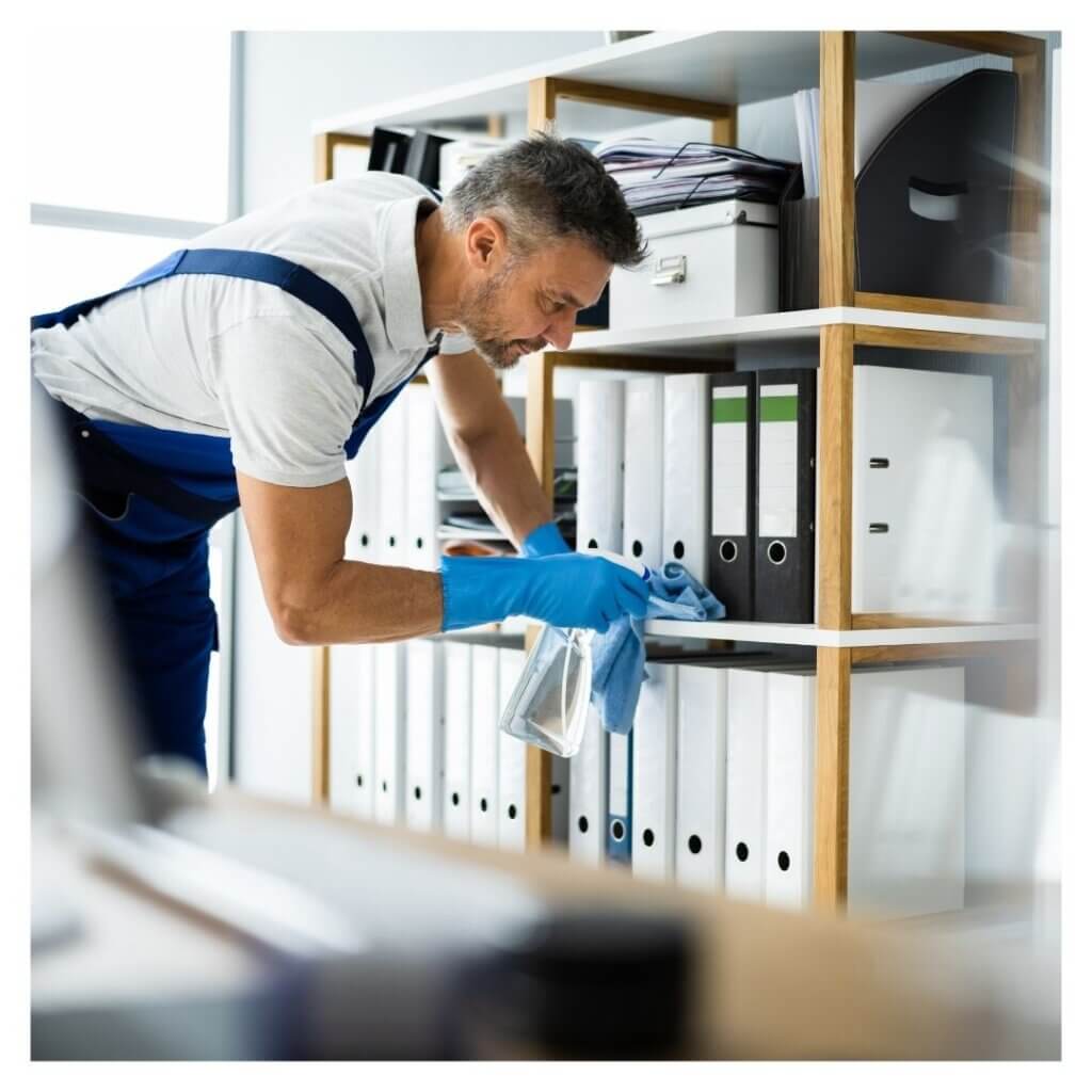 person wearing gloves cleans shelves with business files