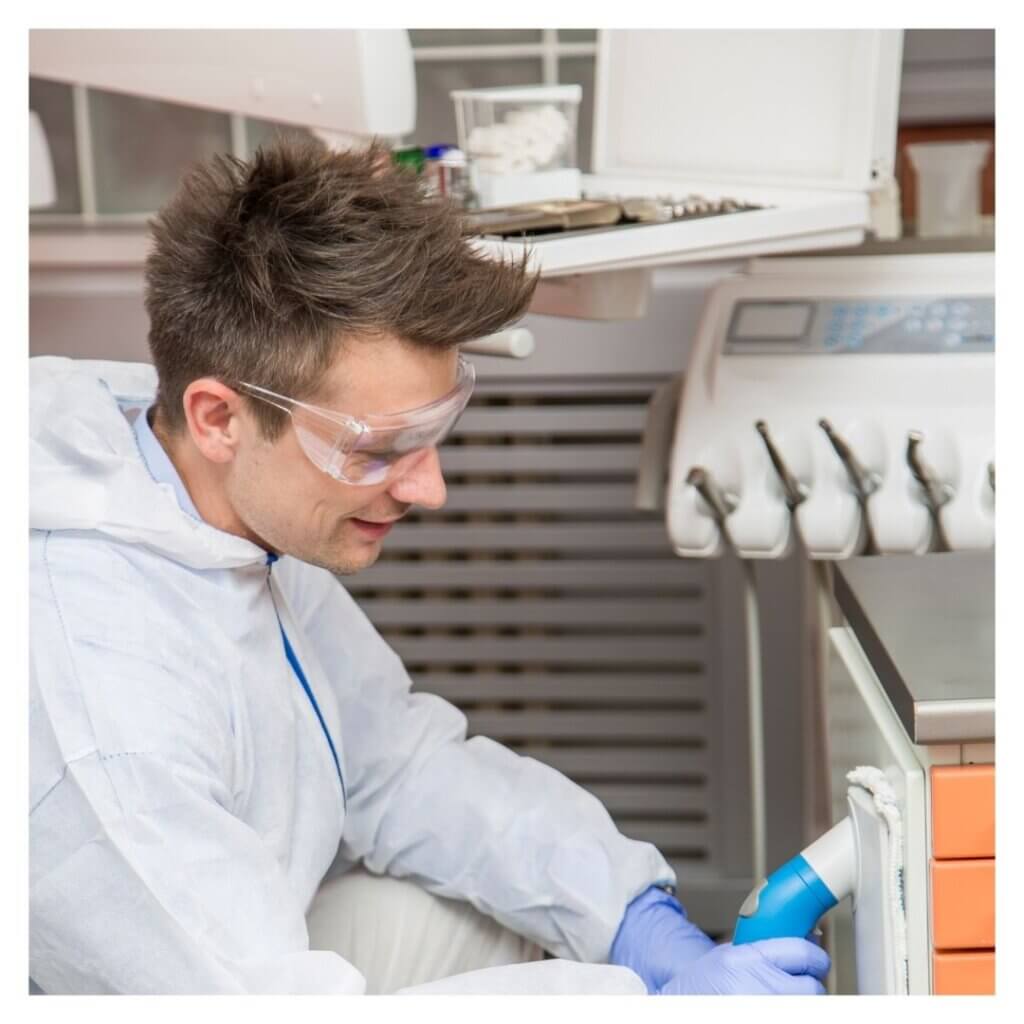 person in safety gear sanitizes medical office 