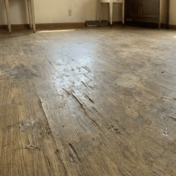 a heavily scratched, dull vinyl flooring