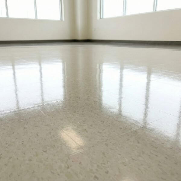 A freshly waxed, highly reflective commercial linoleum floor gleaming under natural light from windows.
